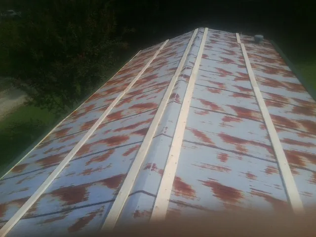 Rusted metal roof panels with new wood purlins before replacement — Storm Damage Roof Repair in Lyndeborough by Roofing Brothers