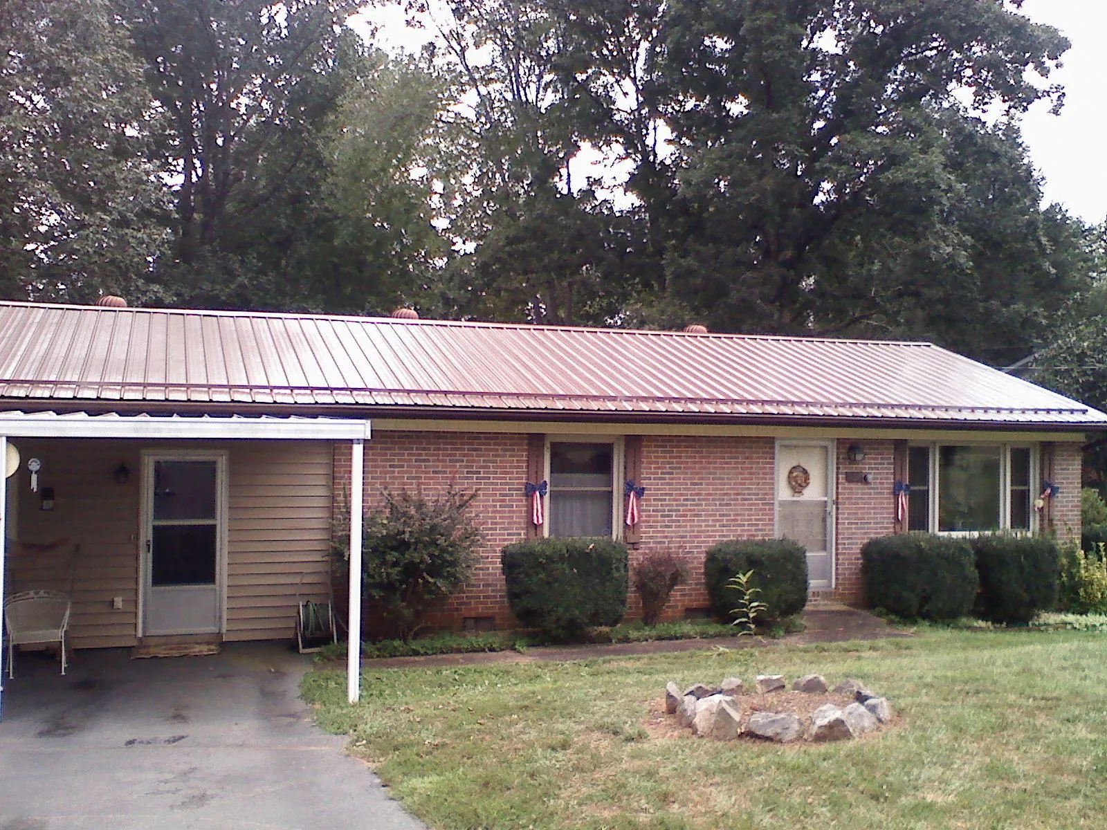 Bronze metal roof and carport on a brick ranch home — Roof Repair work by our crew in Lyndeborough